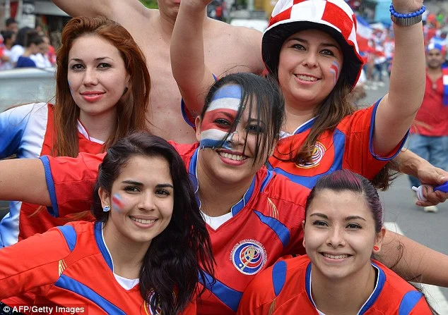 Costa Rica football team fans with nation flag on color on faces Costa Rica football team fans with nation flag on color on faces